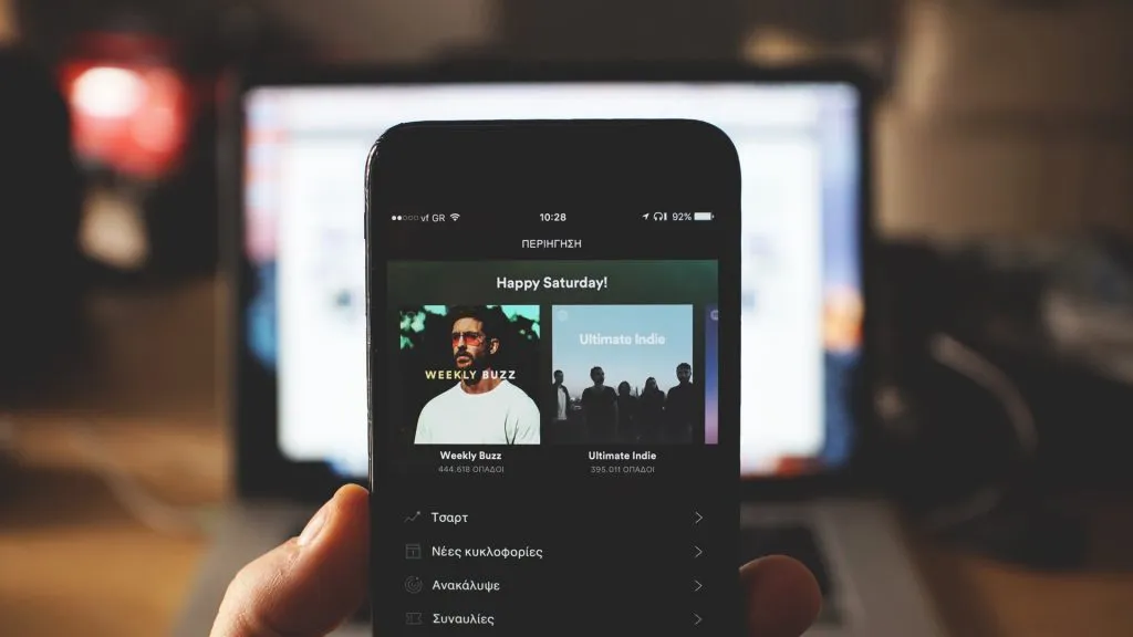 person using smartphone with spotify app on the screen